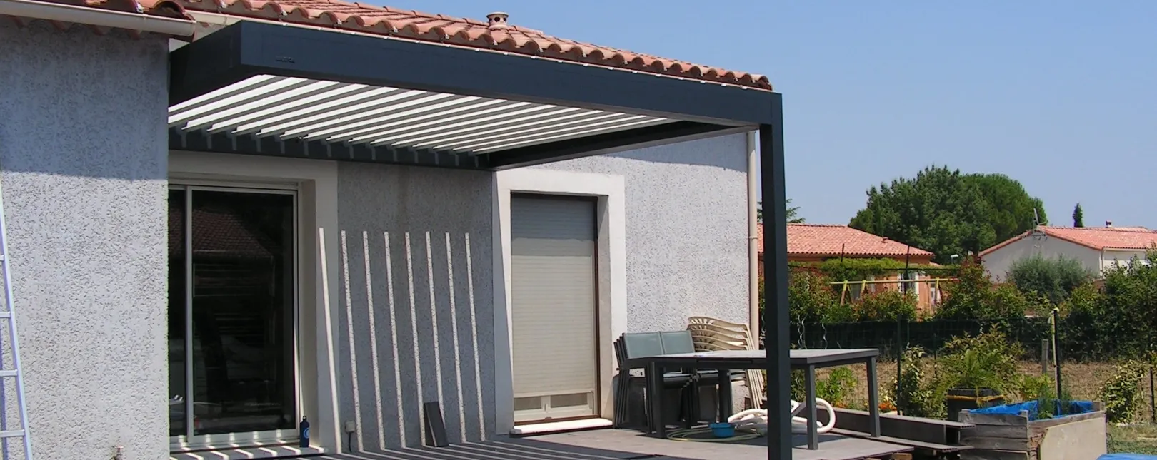 Pose d'une pergola bioclimatique BRUSTOR avec fixation murale et 1 poteau à Fons