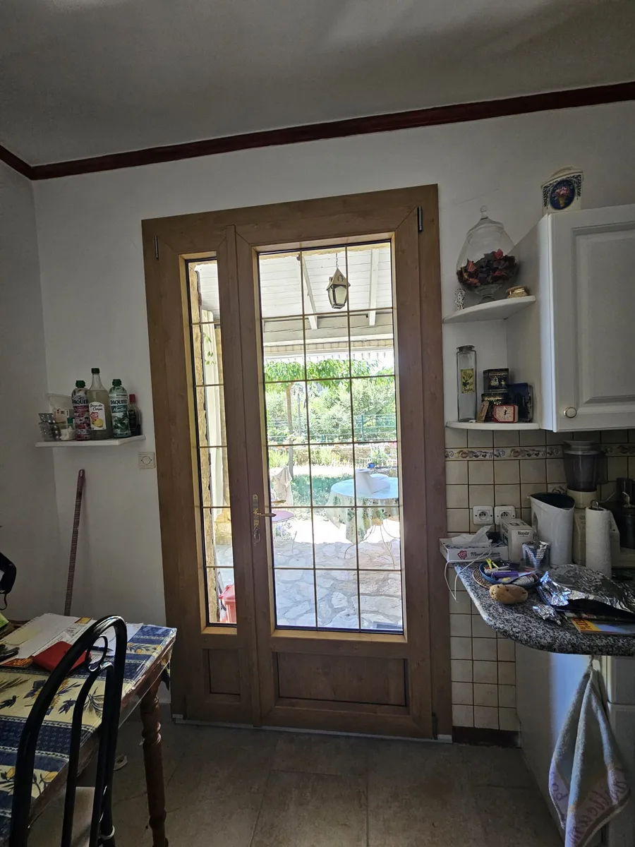 Porte-fenêtre PVC chêne irlandais vue de l'intérieur d'une cuisine à Arpaillargues.