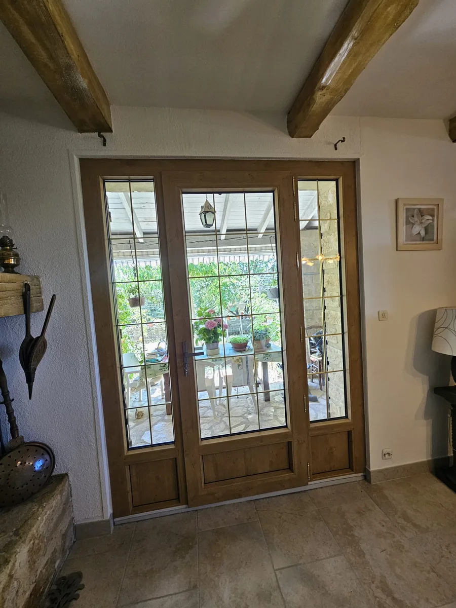 Grande porte-fenêtre PVC chêne irlandais avec imposte vue de l'intérieur du salon.