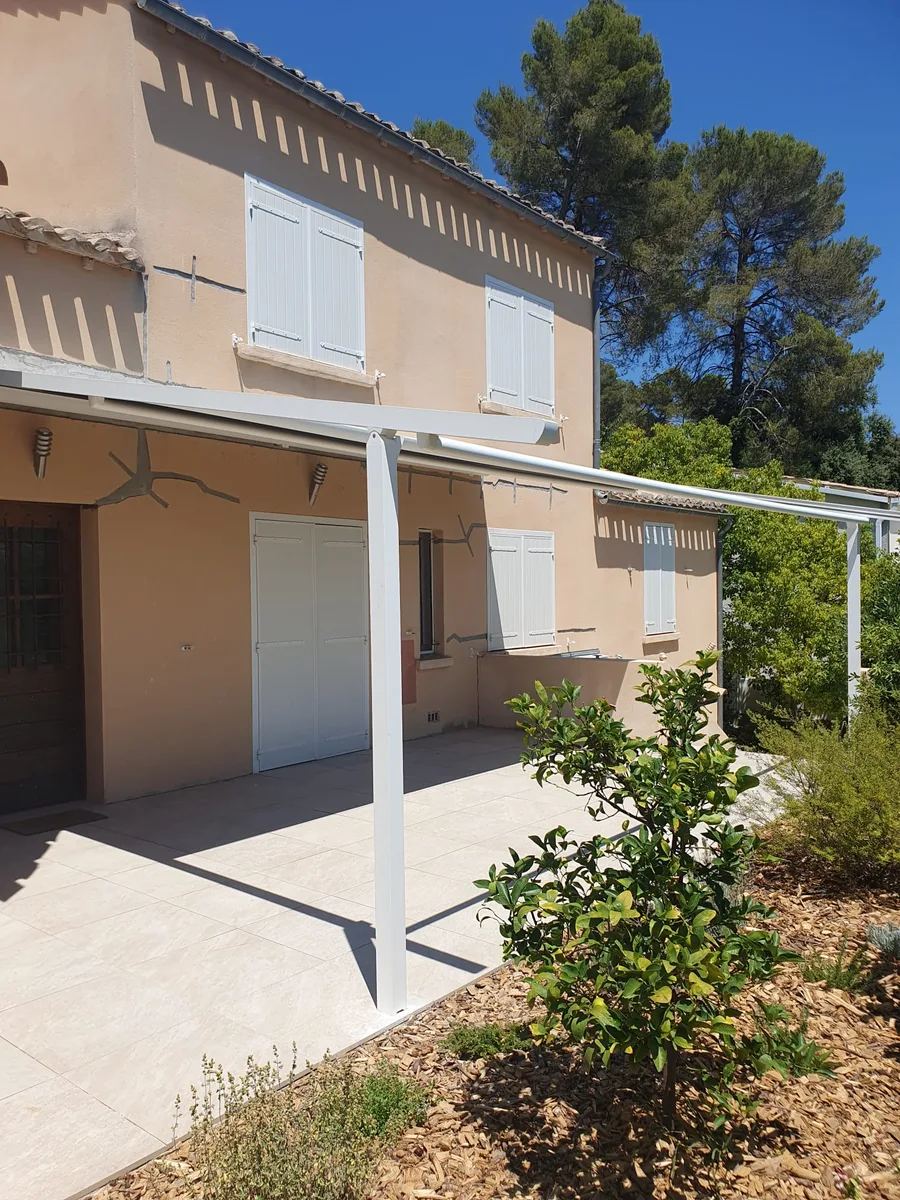Pergola Brustor avec toile anthracite déployée, ombrageant la terrasse.