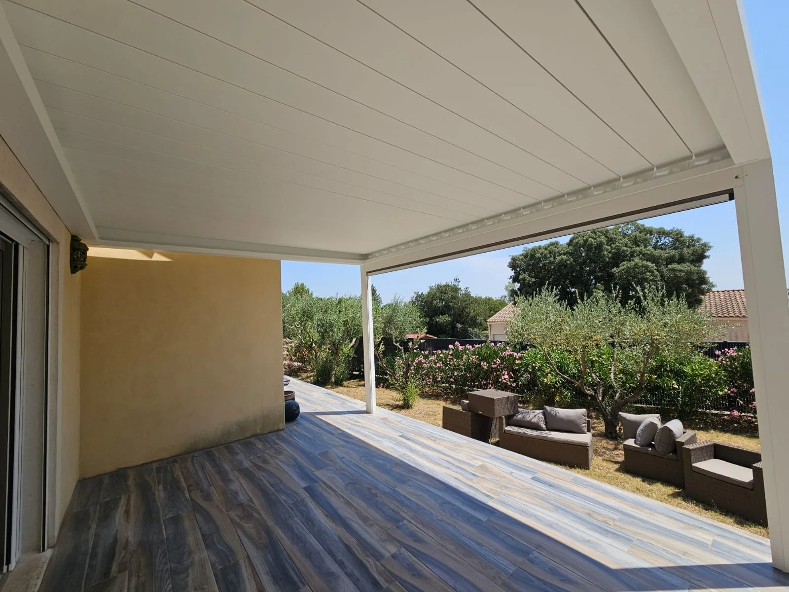 Plafond de lames fermées abritant la terrasse, jardin d'oliviers et lauriers-roses