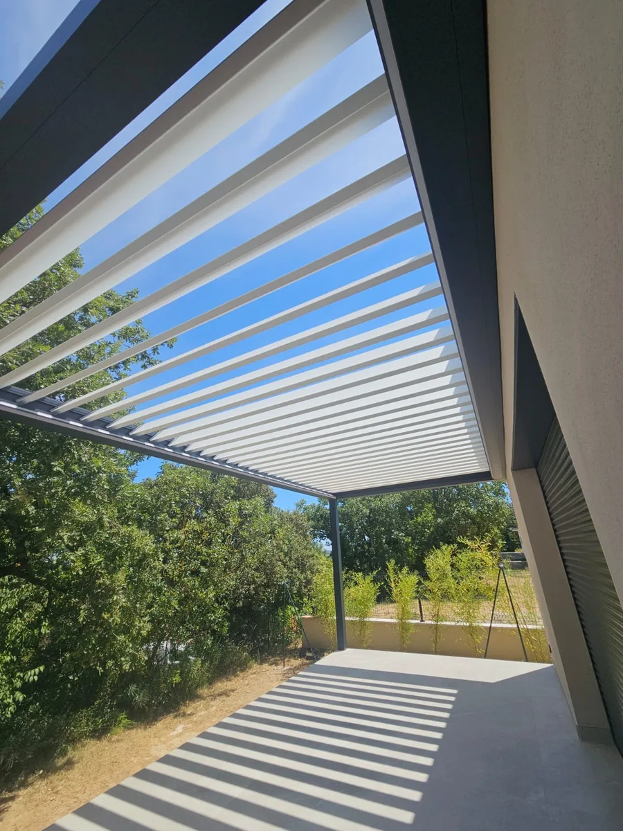 Vue rapprochée de la pergola bioclimatique Brustor avec lames blanches fermées à Montignargues.