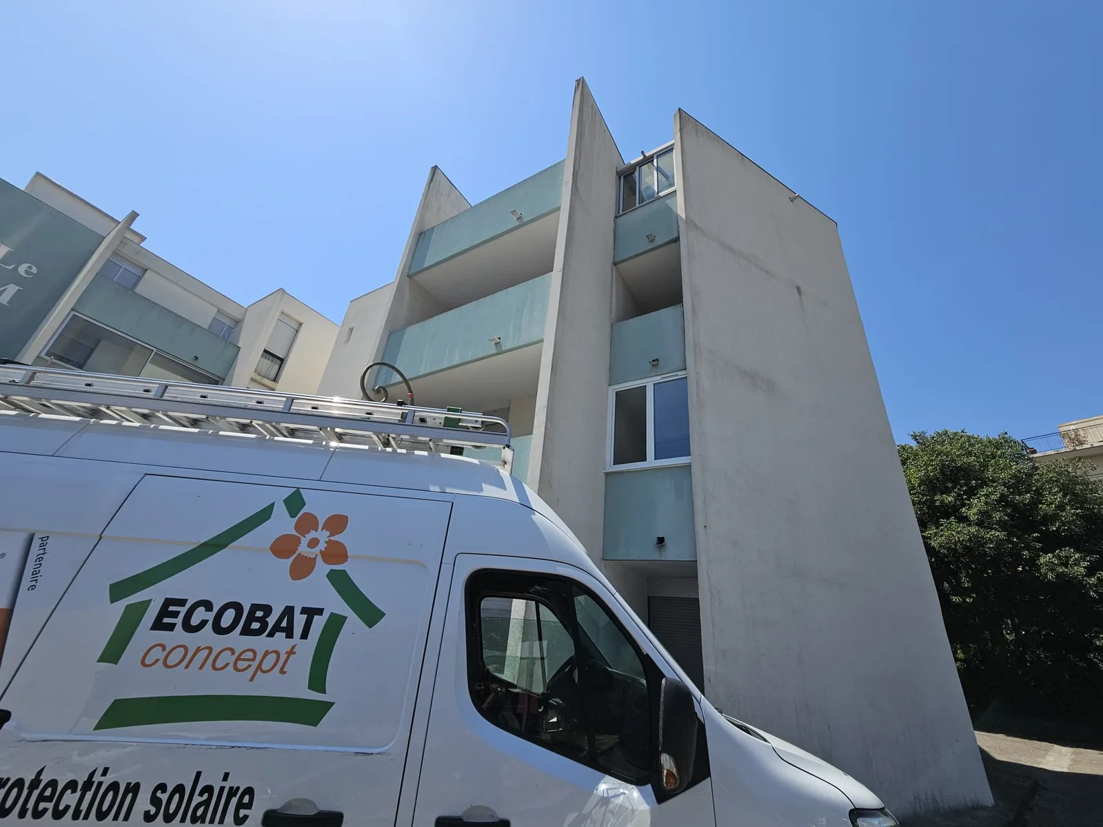 Camion ECOBAT Concept devant un bâtiment moderne avec balcons à Nîmes.