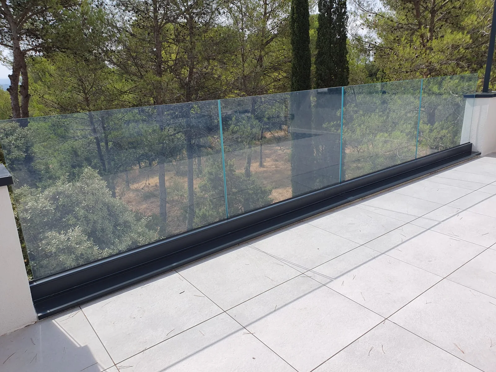 Détail du système de garde-corps en verre sur une terrasse à Nîmes.