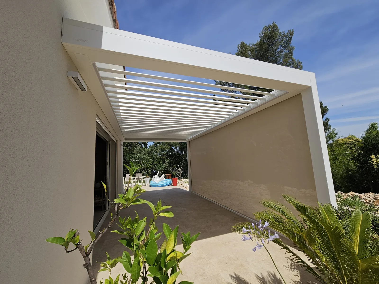 Pergola bioclimatique blanche Brustor avec lames fermées pour une protection solaire maximale à Nîmes.